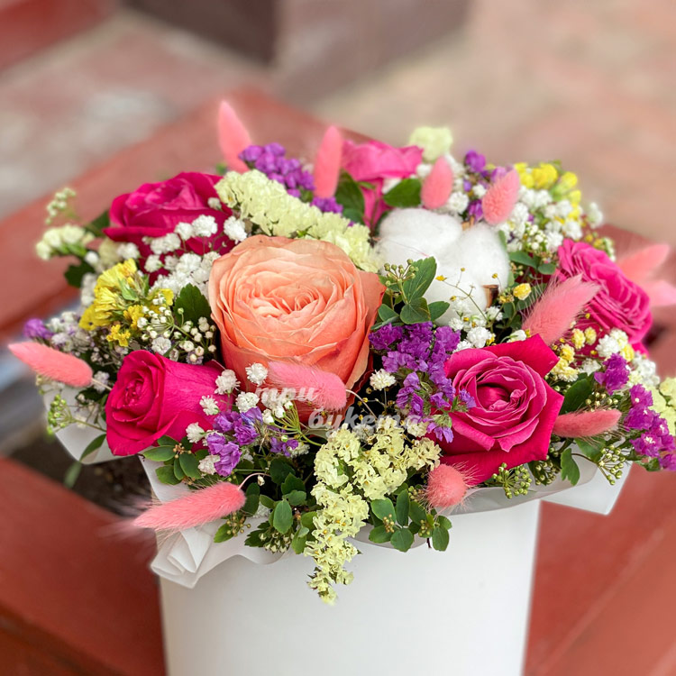 Яркая коробка с розами и статицей (крупный план)