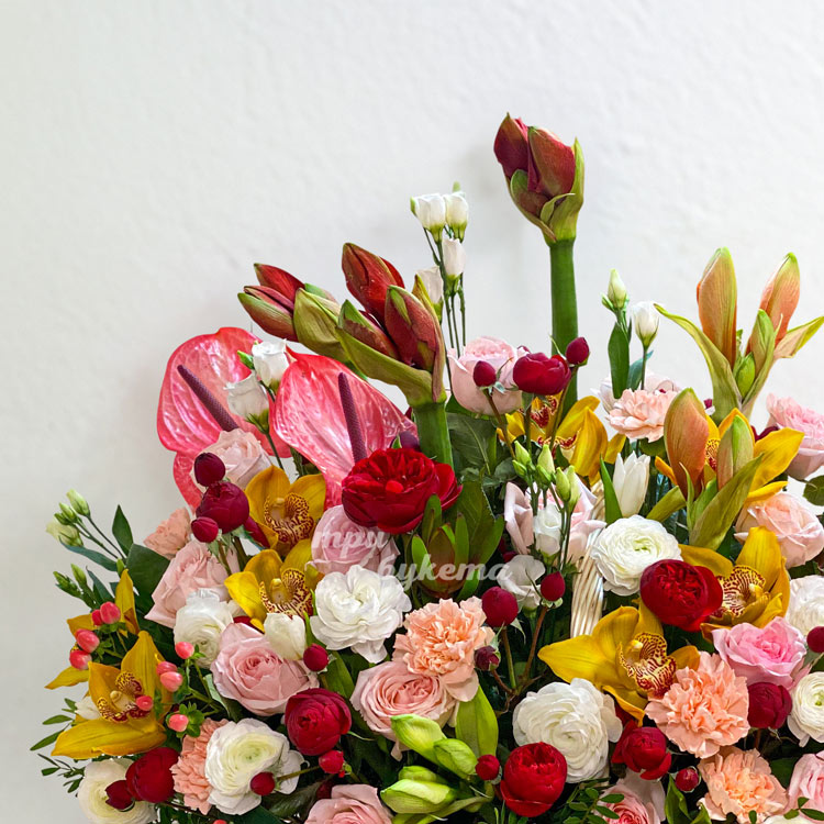 Корзина ярких роз, орхидей и амариллисов (крупный план слева)